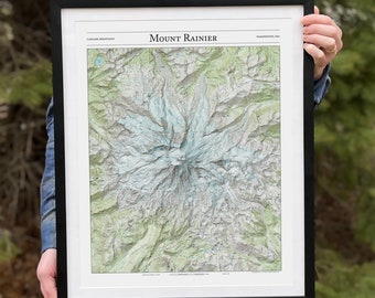 May include: A framed topographic map of Mount Rainier in Washington State. The map shows the mountain's peaks, valleys, and glaciers in detail. The title "Mount Rainier" is printed at the top of the map.