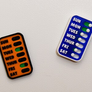 A vivid comparison of magnetic sliders for weekly checklist, showcasing diverse color options for personalized organization: white, black, pink, translucent red, orange, purple, blue, turquoise, green, yellow, copper, silver, and gold.
