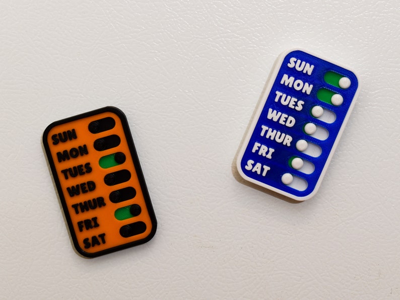 A vivid comparison of magnetic sliders for weekly checklist, showcasing diverse color options for personalized organization: white, black, pink, translucent red, orange, purple, blue, turquoise, green, yellow, copper, silver, and gold.