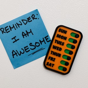 A checklist placed beside a note boldly stating Reminder: I AM AWESOME, highlighting its compact and versatile design. Set goals and cultivate positive habits of showing yourself kindness and gratitude with with a personalized checklist.