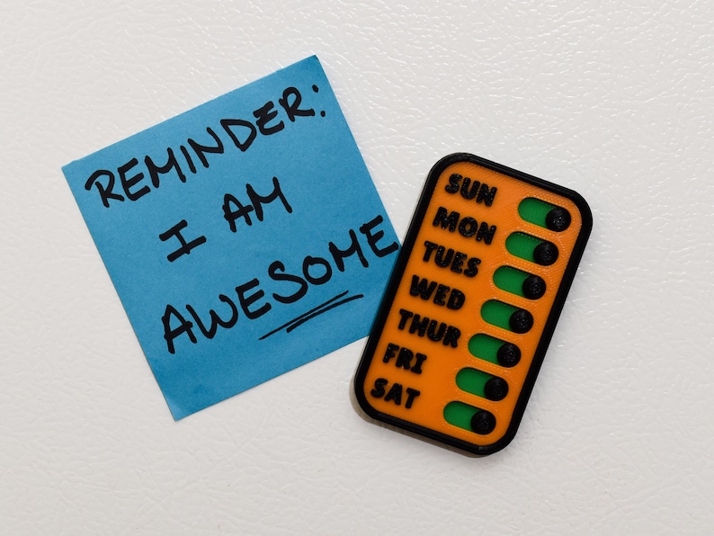 A checklist placed beside a note boldly stating Reminder: I AM AWESOME, highlighting its compact and versatile design. Set goals and cultivate positive habits of showing yourself kindness and gratitude with with a personalized checklist.