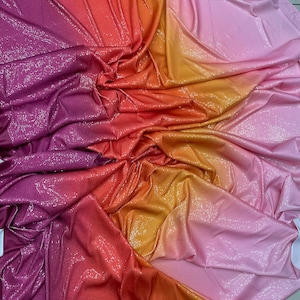 May include: A gradient fabric with a sparkly finish. The fabric transitions from a deep purple to a bright orange and then to a light pink.