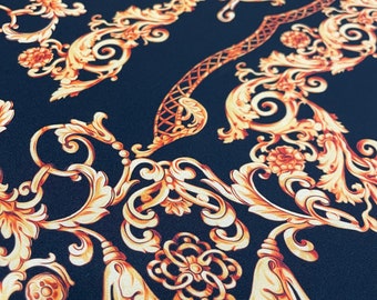 May include: Black fabric with a gold and orange baroque pattern. The pattern features intricate swirls and floral designs.