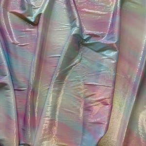 以下が含まれることがあります： 光沢のある、テクスチャ加工された表面を持つ、虹色の生地。 ピンク、青、黄色などのパステルカラーが混ざり合い、柔らかく、幻想的な外観を作り出しています。 素材はドレープされており、折り目とハイライトが示されています。