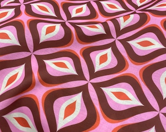 Puede incluir: Primer plano de una tela rosa con un patrón geométrico repetitivo. El diseño presenta formas de hojas marrones, blancas y naranjas sobre un fondo rosa. La tela tiene una estética retro y moderna de mediados de siglo.