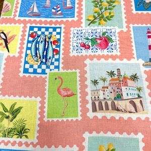 May include: A fabric with a repeating pattern of postage stamp-like squares. Each square features a different illustration, including sailboats, lemons, fish, a flamingo, and a coastal town. The background is a light pink color.
