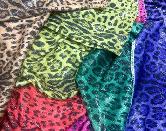 May include: A stack of six different leopard print fabrics with sequins. The fabrics are in the colors brown, green, red, pink, blue, and purple.