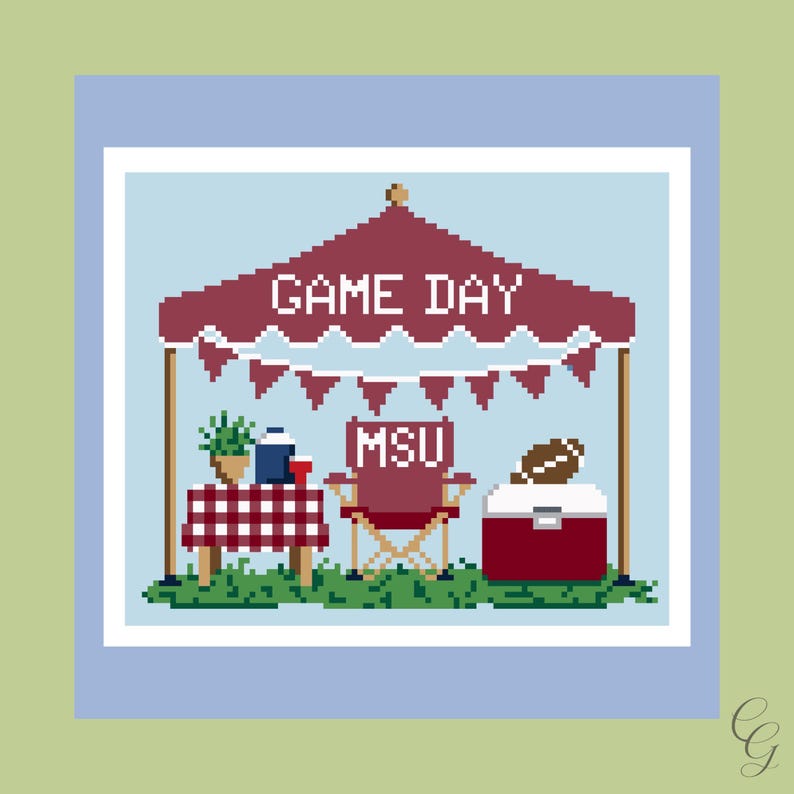 May include: A pixel art cross stitch pattern featuring a maroon canopy tent with the text GAME DAY, a table with a red and white checkered cloth, a maroon folding chair labeled MSU, and a maroon cooler topped with a brown football on green grass.