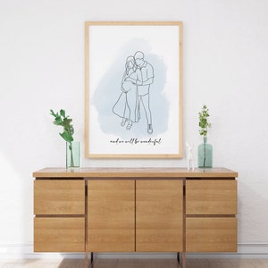 May include: A framed line drawing of a couple embracing, with a blue watercolor background. The text "and we will be wonderful" is below the drawing.