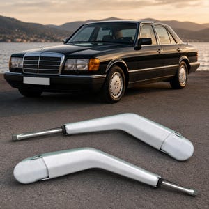 May include: Two silver-colored metal windshield wiper arms with a curved, angular design. Each arm features a smooth finish, a mounting point at one end, and a straight metal attachment rod extending from the base, presented as automotive parts.