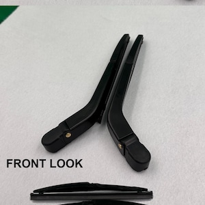 May include: Four black wiper blades, two are shown from the front and two from the back. The blades are made of metal and plastic and have a gold-coloured hook. The text "4 PIECE" is printed on the image.