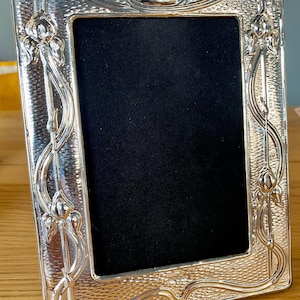 Sterling Silver Photograph frame. Art Nouveau style, with Lillies. Photo size 6”x4”. Fully Hallmarked in London, including date.
