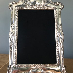 Sterling Silver Photograph frame. Fully Hallmarked in London, including date. Photo size 6”x 4” with beautiful wooden back, made in England.