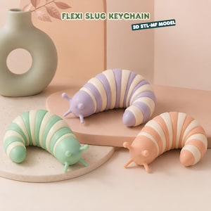 May include: Three segmented slug-shaped keychains in pastel colors: one purple and white, one mint green and white, and one peach and white. Each slug features two antennae and a curved body. Text reads FLEXI SLUG KEYCHAIN and 3D STL-MF MODEL.