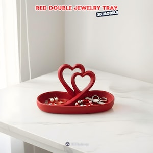 May include: A red double jewelry tray with a heart-shaped design. The tray holds various jewelry items, including rings, pearls, and bracelets. The text "RED DOUBLE JEWELRY TRAY" is at the top of the image.
