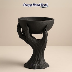 Puede incluir: Un cuenco negro sostenido por una mano esculpida con uñas largas. El cuenco y la mano tienen un acabado texturizado, posiblemente de material oscuro. El texto "Creepy Hand Bowl" está en la parte superior, con "3D Models" debajo.