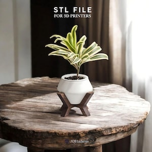 May include: A white ceramic planter with a geometric design sits on a wooden stand with a hexagonal base. The planter is filled with a green and yellow plant. The text "STL FILE FOR 3D PRINTERS" is visible in the top left corner of the image.