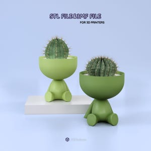 Pode incluir: Duas floreiras verdes em forma de figura, cada uma com um cacto. As floreiras têm um topo arredondado em forma de tigela e uma base em forma de figura sentada. Os cactos são verdes com detalhes brancos. O texto na parte superior diz "STL FILE & 3MF FILE FOR 3D PRINTERS."