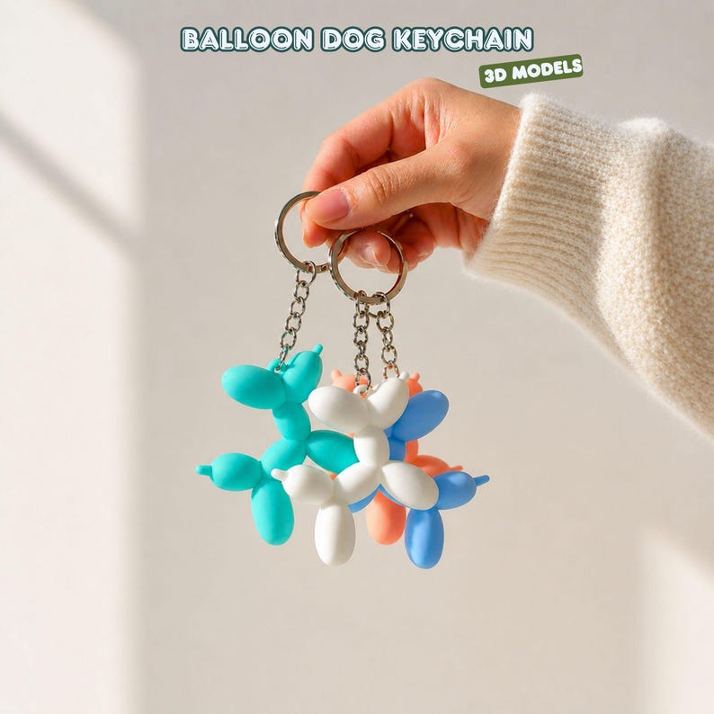 Puede incluir: Una mano sostiene dos llaveros con colgantes de perro globo. Los colgantes son de varios colores, incluyendo turquesa, blanco, azul y coral. Los llaveros tienen anillos y cadenas plateadas. El texto "BALLOON DOG KEYCHAIN" y "3D MODELS" es visible.
