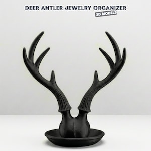 May include: A black deer antler jewelry organizer with a round base. The antlers are stylized and extend upwards. The text "DEER ANTLER JEWELRY ORGANIZER" and "3D MODELS" are at the top of the image.