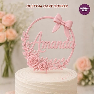 May include: A pink cake topper with the name "Amanda" in a cursive font. The topper has a circular design with a bow, roses, and leaves. The text "CUSTOM CAKE TOPPER" and "DIGITAL FILES" are also visible.