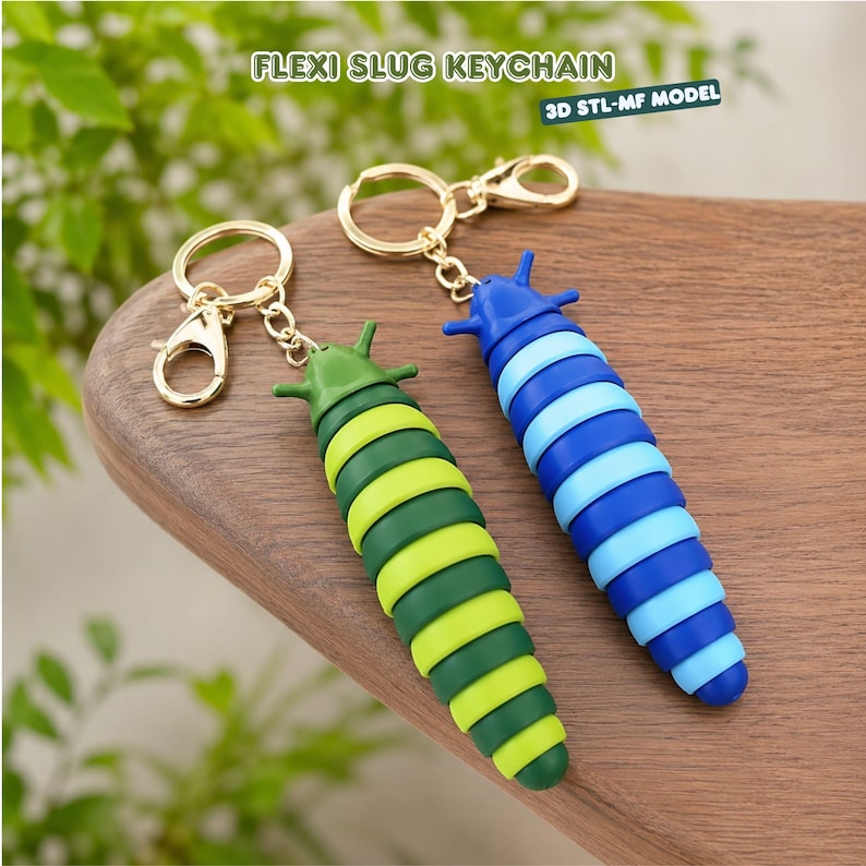 May include: Two articulated slug keychains with gold-tone metal rings and lobster clasps. One slug features alternating dark and light green segments, while the other has alternating dark and light blue segments. Text reads FLEXI SLUG KEYCHAIN.