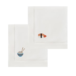Op de afbeelding: Twee witte vierkante servetten met geborduurde voedselontwerpen. Eén servet heeft een kom rijst met eetstokjes, de andere een sushirol. De servetten hebben een gestikte rand.