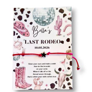 May include: A red string bracelet with a black star charm, presented on a card with a cowgirl theme. The card features illustrations of a cowboy hat, boots, and a disco ball, with the text "Bella's Last Rodeo 10.05.2026".