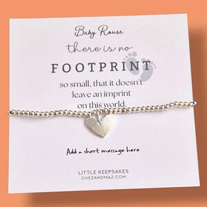 May include: A silver beaded bracelet with a heart charm is displayed on a white card. The card features the text: "Baby Rouse there is no FOOTPRINT so small, that it doesn't leave an imprint on this world."