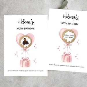 May include: Two white rectangular cards featuring the text Helena's 60TH BIRTHDAY. Each card displays a pink heart-shaped balloon tied to a pink gift box with small hearts. One card shows a photo behind a scratch-off circle, the other says Better luck next time.