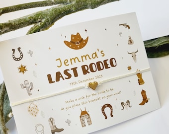 May include: White string bracelet with a gold heart charm and a card with a western theme. The card says "Jemma's Last Rodeo" and "13th December 2023".