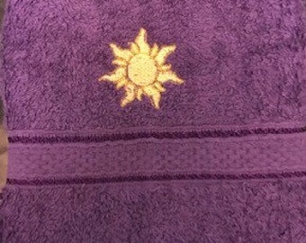 Purple face cloth with embroidered Rapunzel Sun emblem