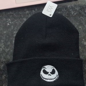 Peut inclure: Bonnet noir avec un visage brodé blanc de Jack Skellington du film L'Étrange Noël de monsieur Jack.