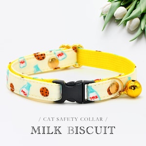 Può includere: Un collare di sicurezza per gatti giallo con sfondo bianco che presenta un motivo ripetuto di bottiglie di latte e biscotti con gocce di cioccolato. Il collare ha una fibbia nera e un campanello dorato.