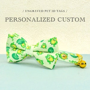 May include: A green and white cat collar with a bow tie featuring a frog pattern. The collar has a gold bell and a gold buckle.  / ENGRAVED PET ID TAGS / PERSONALIZED CUSTOM