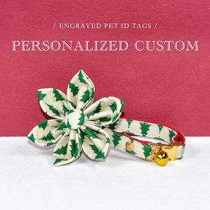 May include: A cream-coloured pet collar and flower accessory, patterned with green Christmas trees. The collar has a red trim and a gold bell. The image includes the text: "Engraved Pet ID Tags / Personalized Custom".