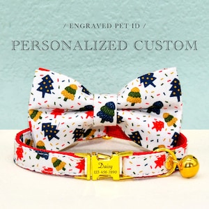 May include: A white and red pet collar with a gold buckle and a bell. The collar has a festive pattern of Christmas trees and confetti. The buckle has the text "Daisy" and a phone number. The collar is paired with a matching bow tie.