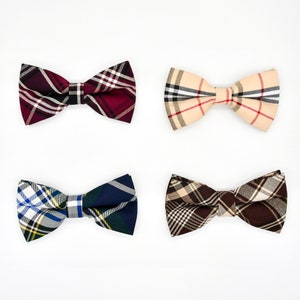 May include: Four bow ties in different plaid patterns: red and black, beige and brown, blue and yellow, and brown and beige.