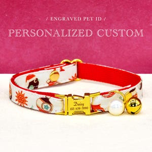 May include: A personalized pet collar with a white patterned design and a red interior. The collar features a gold-colored buckle engraved with a name and phone number, a pearl, and a gold bell. The text "PERSONALIZED CUSTOM" is visible.