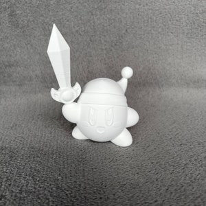 May include: A white 3D printed figurine of a pink character holding a sword. The character has a large head with a white hat and a small body. The character has a friendly expression with large eyes and a small mouth.