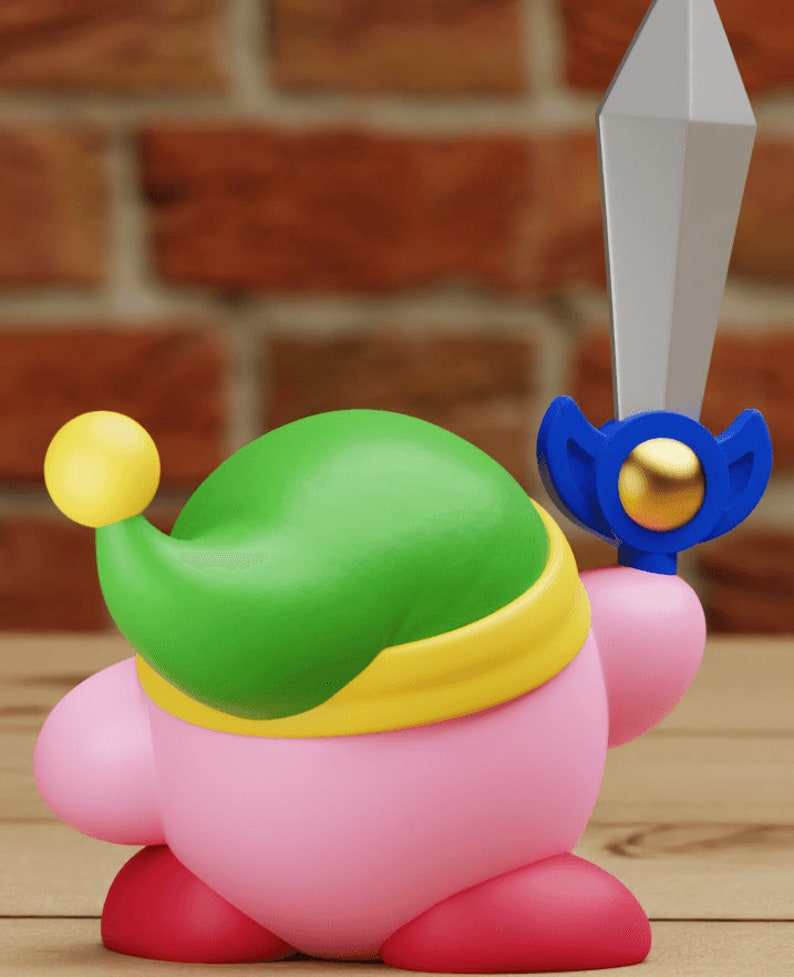 May include: A pink and green character with a yellow headband and a blue sword. The character is wearing a green hat with a yellow ball on top.