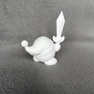 May include: White 3D printed figurine of a character holding a sword. The character is round and has a pointed hat.