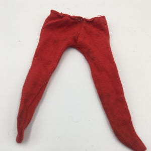 May include: A pair of bright red, slim-fitting pants made from a soft, knit fabric. The garment features a simple, pull-on design with a narrow waistband and long, tapered legs that extend downward, showcasing a solid, vibrant red color throughout.