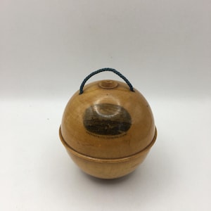 Puede incluir: Un recipiente de madera con forma de huevo con un asa de cuerda azul. El recipiente tiene una pequeña imagen de una ciudad en el lateral con el texto "Greenwich, Connecticut, USA".