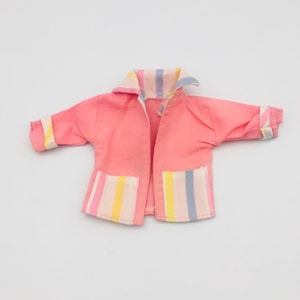 May include: A vintage pink jacket with a collar and two front pockets. The collar, cuffs, and pockets feature pastel stripes in yellow, blue, and pink. The jacket is open in the front.