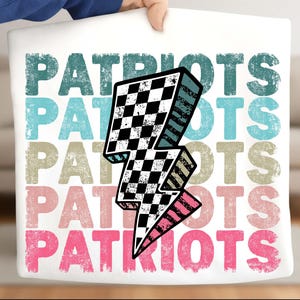 May include: White tote bag featuring the word "PATRIOTS" in a layered design with a checkered lightning bolt graphic. The text is in teal, light blue, tan, and pink. The bag is held by a person.
