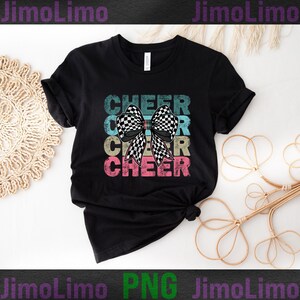 Op de afbeelding: Zwart T-shirt met een vintage-stijl grafische afbeelding van het woord "CHEER" dat drie keer wordt herhaald met een zwart-wit geblokte strik in het midden.