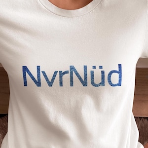 May include: White t-shirt with the text "NvrNüid" printed in blue on the front.