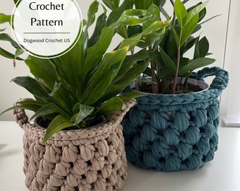 Puede incluir: Dos macetas de plantas de crochet, una de color marrón claro y la otra de color azul turquesa. Las macetas están hechas con un punto texturizado y tienen forma redonda. El texto "Crochet Pattern Dogwood Crochet US" es visible en la esquina superior izquierda de la imagen.