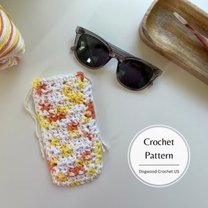 May include: Crochet pattern for a sunglasses case with a white background and orange and yellow stripes. The pattern is called "Dogwood Crochet US".
